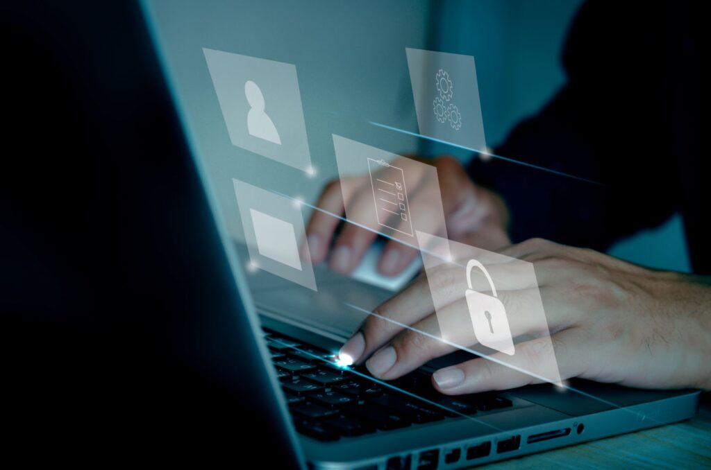 Pessoa digitando em notebook com ícones de segurança e proteção de dados sobrepostos, representando LGPD empresa.